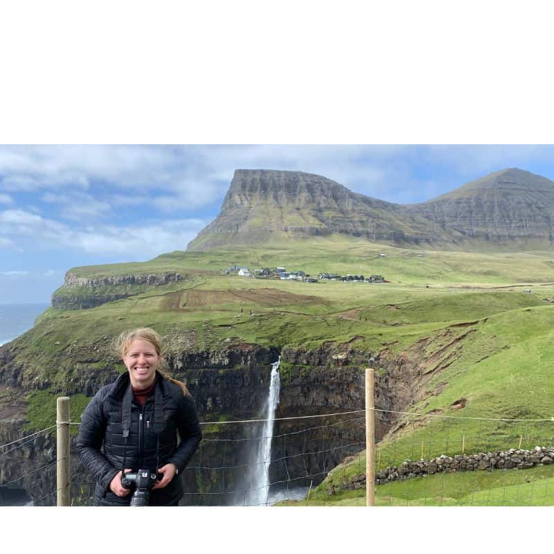 Woman with waterfall and mountains in the background 