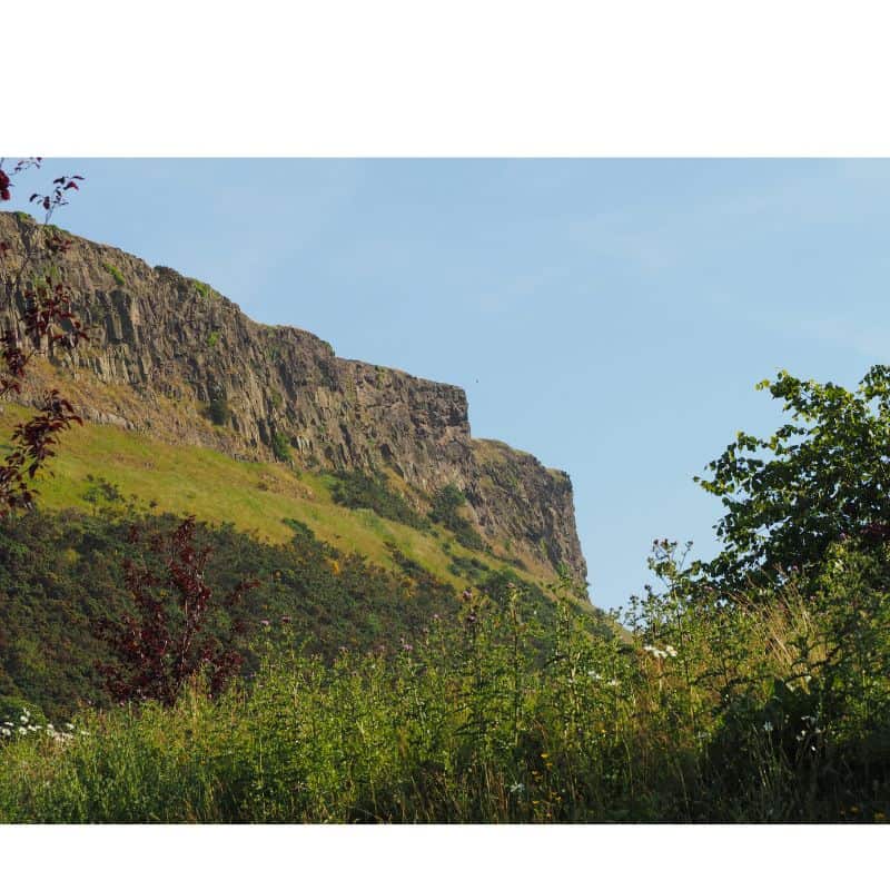 Arthur's Seat Cliffs with green brush and blue skies 
