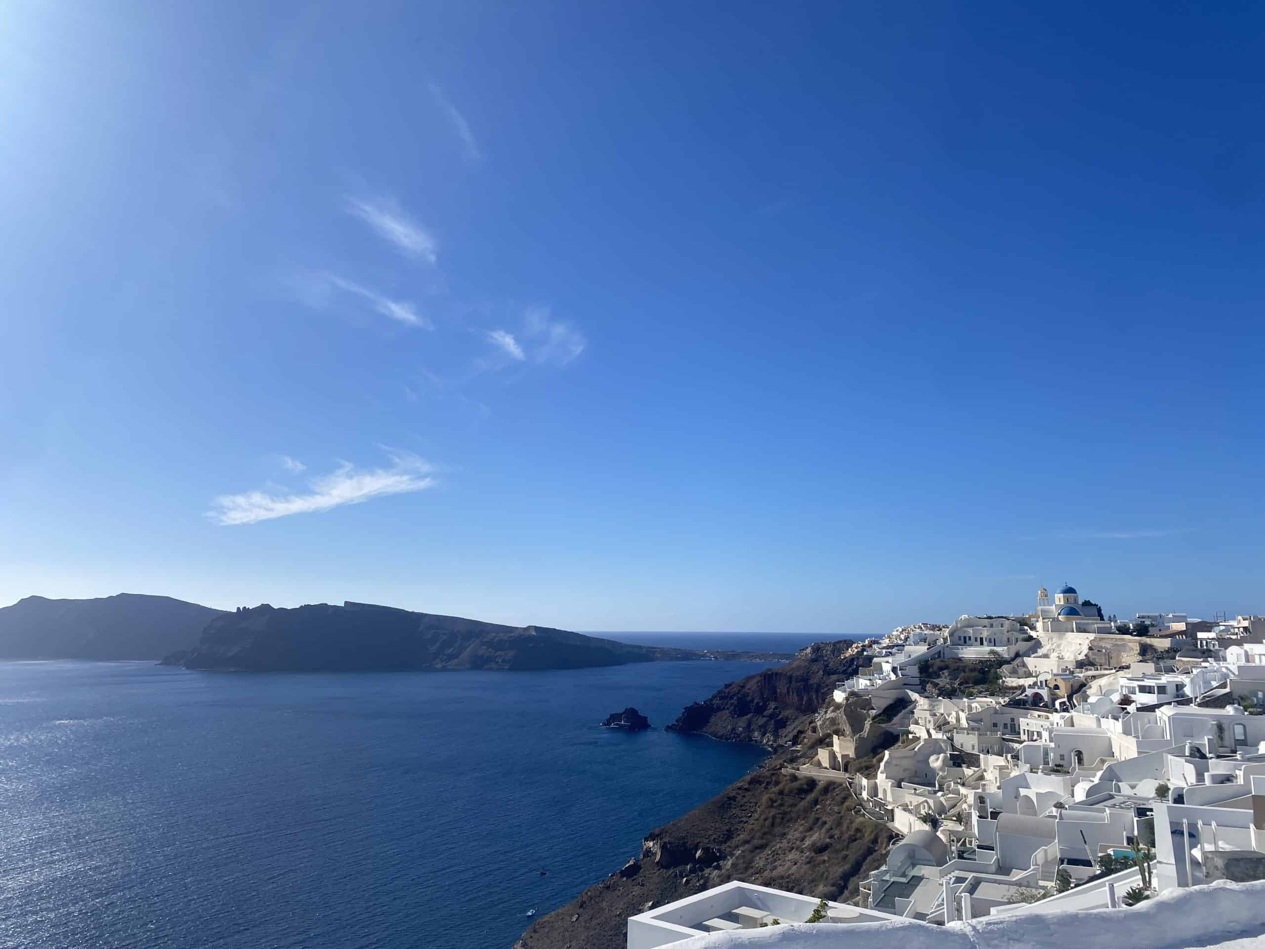 Santorini buildings on one side and ocean and islands on other side 