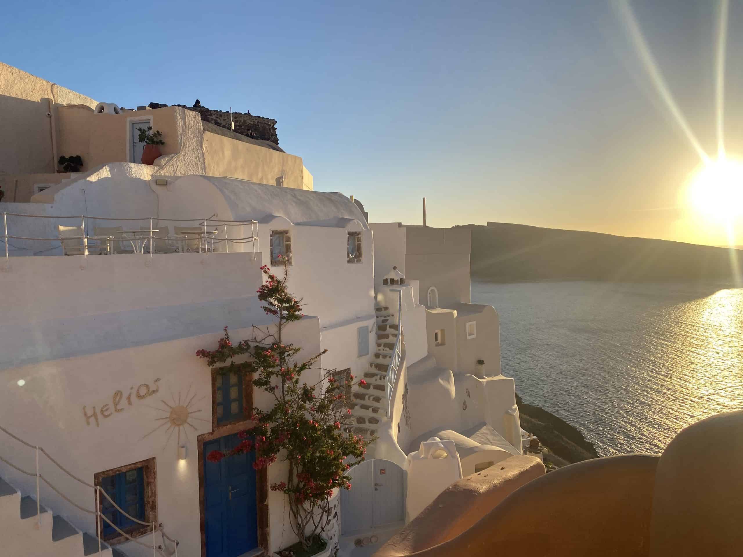 white buildings with flowers and ocean, sun in the corner