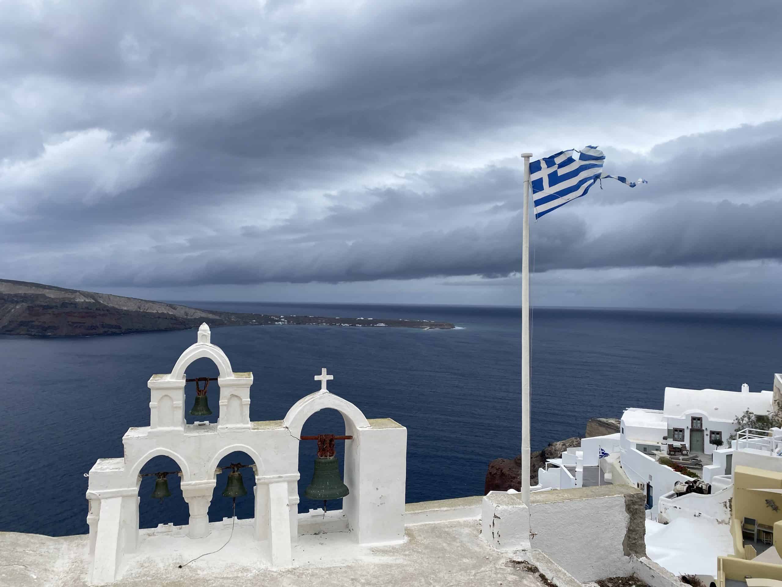White crosses and Greek flag with grey and blue sky 
