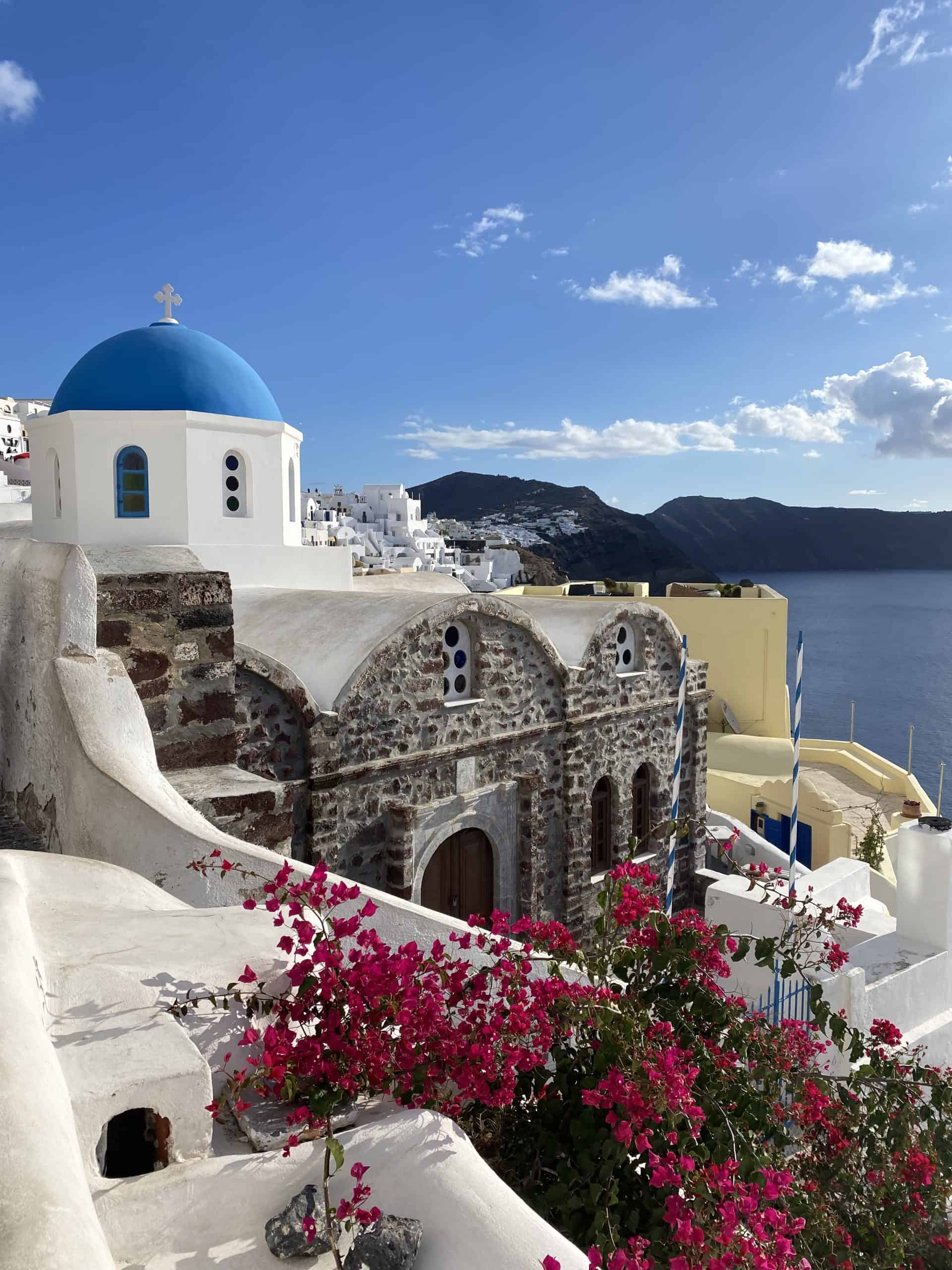 Santorini buildings with blue domes and brick buildings, ocean on the side 