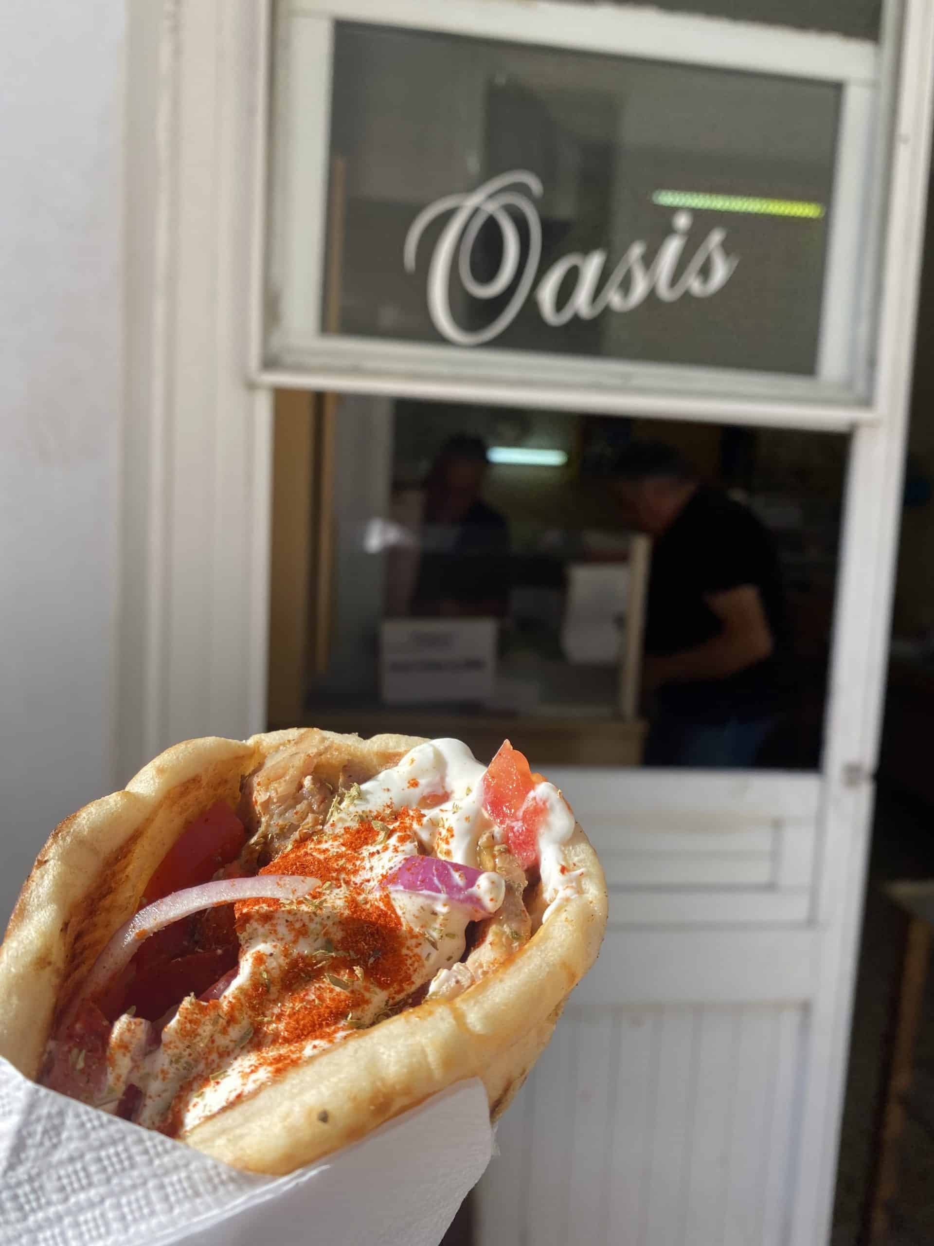 Greek sandwich with restaurant window in the background 