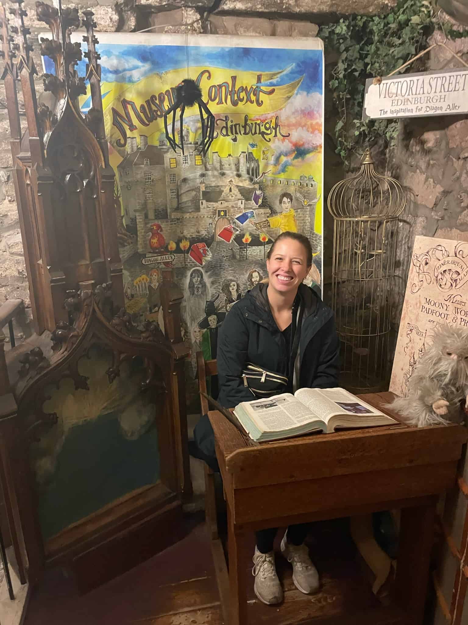Woman sitting in Harry Potter store surrounded by Harry Potter memorabilia 