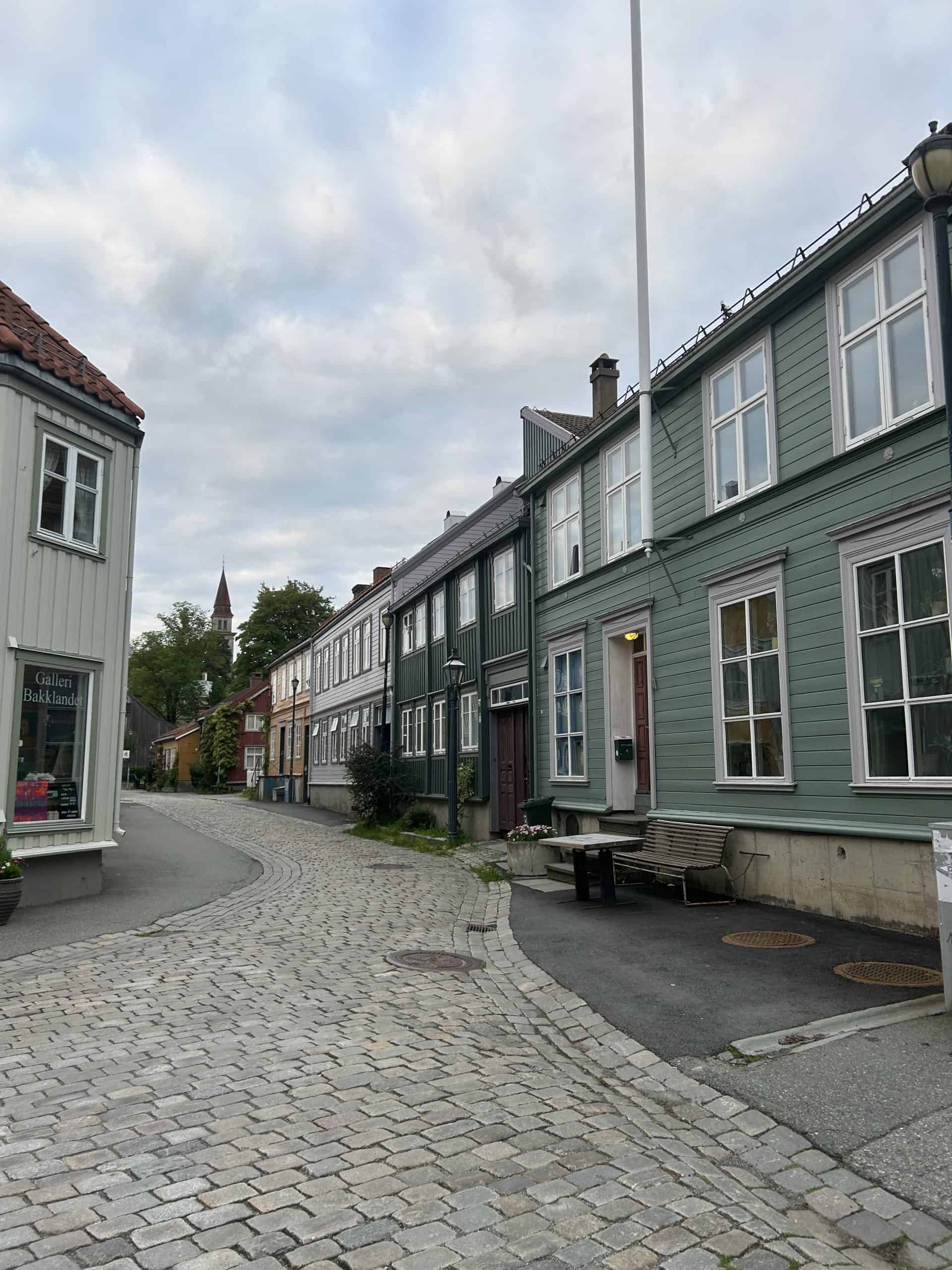 Cobblestone road with colorful buildings in Trondheim.